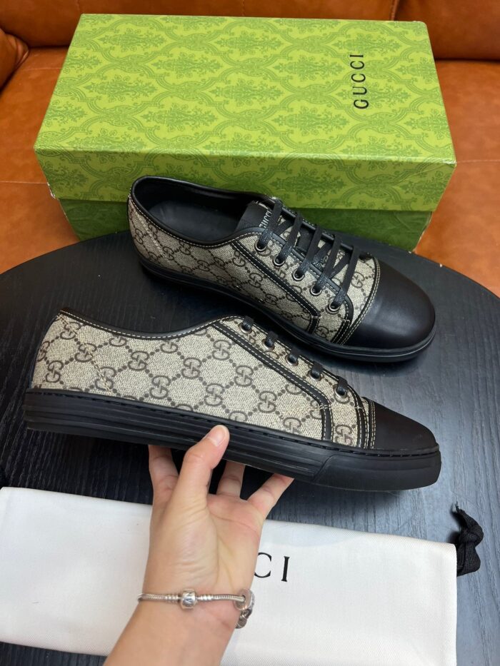 Sneakers Gucci monogramma con dettagli in vernice nera, stile elegante e di lusso sofisticato.