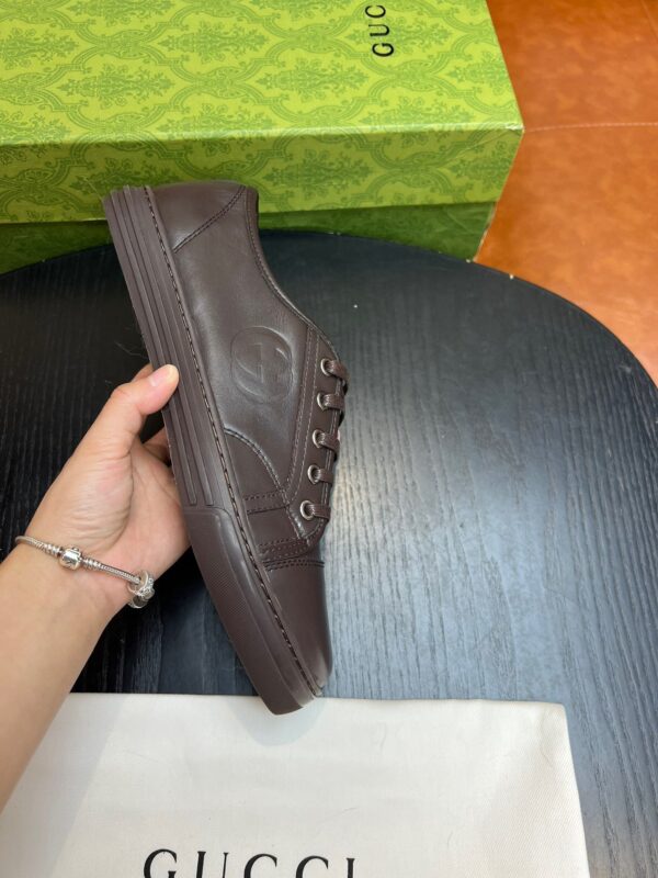 Sneaker uomo marrone in pelle con dettagli moderni e logo di lusso, stile casual e raffinato.