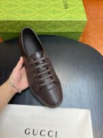 Scarpa Gucci in pelle marrone con scatola verde, eleganza e stile di lusso.