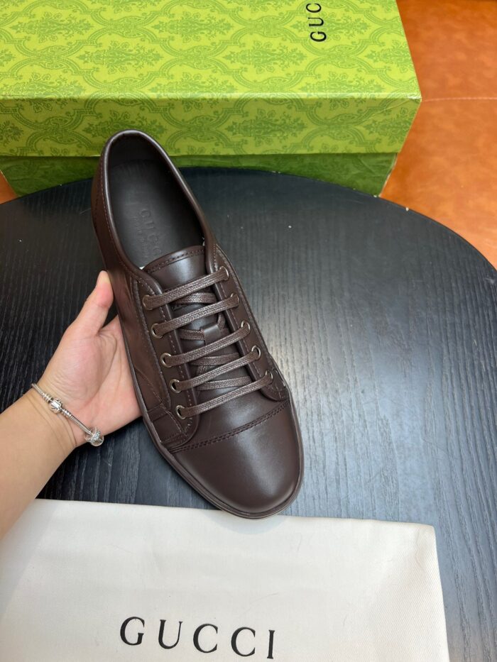 Scarpa Gucci in pelle marrone con scatola verde, eleganza e stile di lusso.