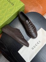 Sneaker Gucci in pelle marrone con scatola di lusso, stile elegante e raffinato.