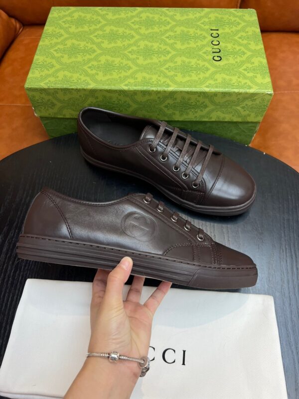 Scarpe Gucci in pelle marrone con packaging di lusso e dettagli eleganti.