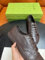 Scarpe da sneaker in pelle marrone con confezione elegante e design di alta qualità.