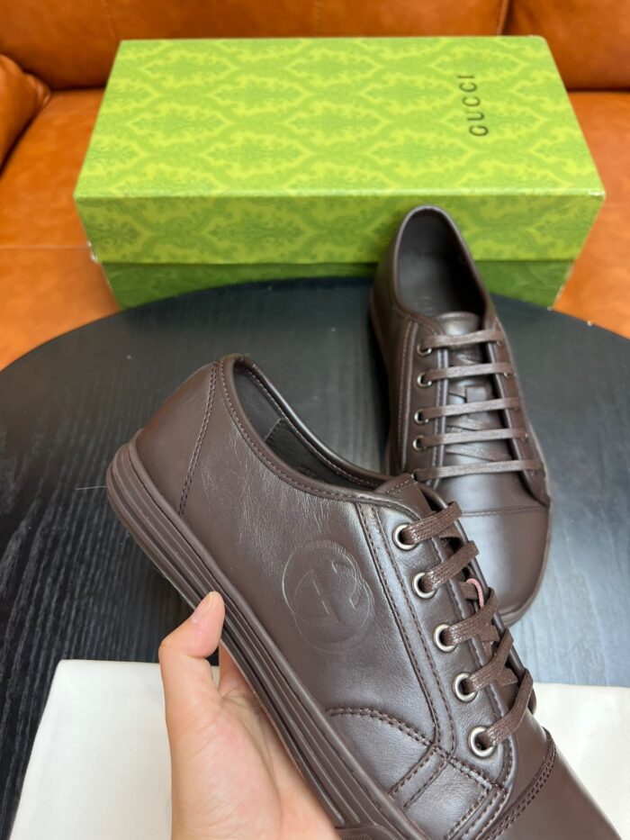 Scarpe da sneaker in pelle marrone con confezione elegante e design di alta qualità.