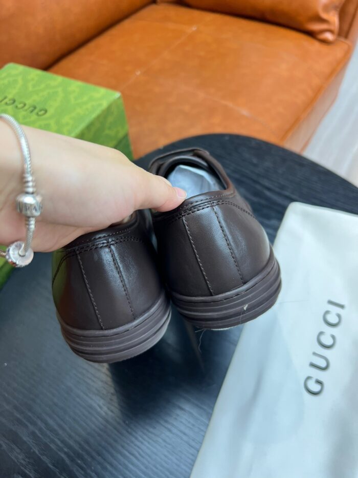 Scarpe Gucci in pelle ricercata su divano arancione, dettaglio elegante e lifestyle di lusso.