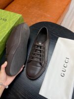 Sneaker Gucci in pelle marrone con confezione di lusso e design elegante.