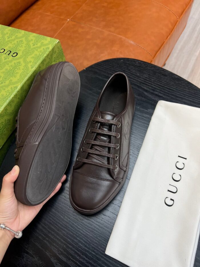 Sneaker Gucci in pelle marrone con confezione di lusso e design elegante.