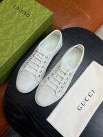 Sneakers bianche Gucci di lusso con sacchetto e scatola verde elegante.