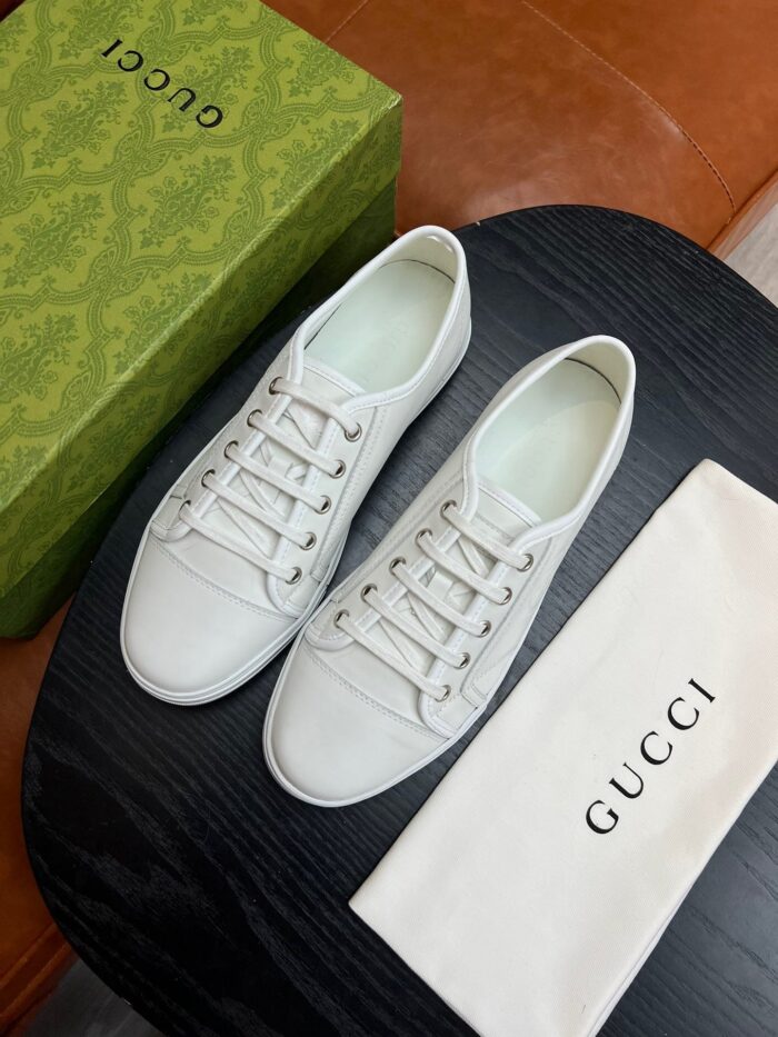 Sneakers bianche Gucci di lusso con sacchetto e scatola verde elegante.
