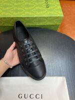 Sneaker nera di lusso con scatola Gucci e dust bag, stile elegante e casual sofisticato.