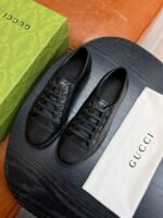Scarpe Gucci di lusso su tavolo nero con dust bag e scatola brandizzata.