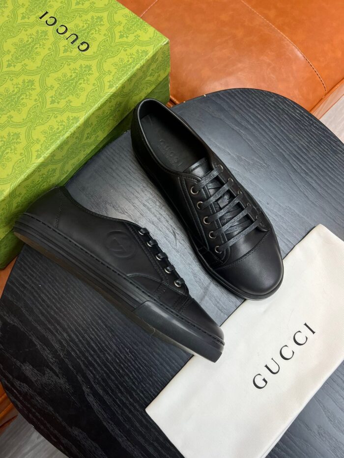 Sneakers Gucci nere in total black con packaging di lusso su superficie in legno scuro
