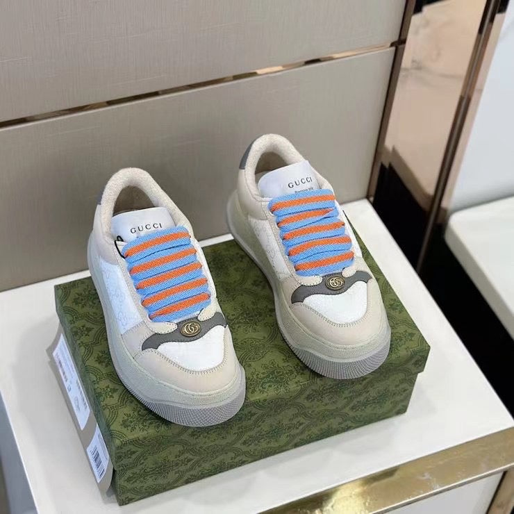 Sneakers Gucci moderne con lacci arancione su scatola decorativa verde, stile luxury streetwear.