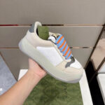 Sneaker moderna in beige con lacci colorati e suola chunky, stile casual e di lusso.