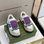 Sneakers Gucci colorate con lacci turchesi su box decorativo elegante.