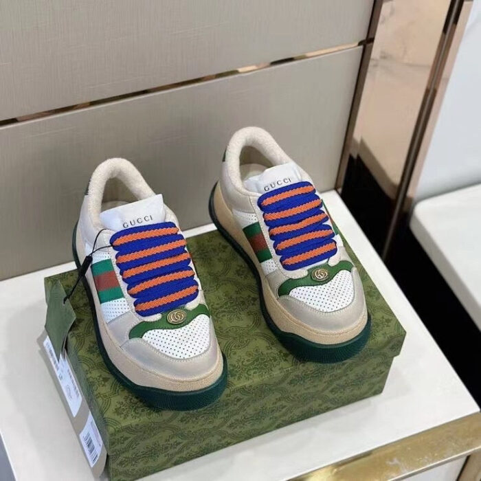 Sneakers Gucci colorate con lacci turchesi su box decorativo elegante.