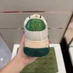 Sneaker Gucci in pelle bianca con dettagli verdi e logo in rilievo sul tallone.