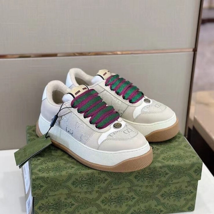Sneaker bianche eleganti con lacci colorati su scatola decorativa di design.
