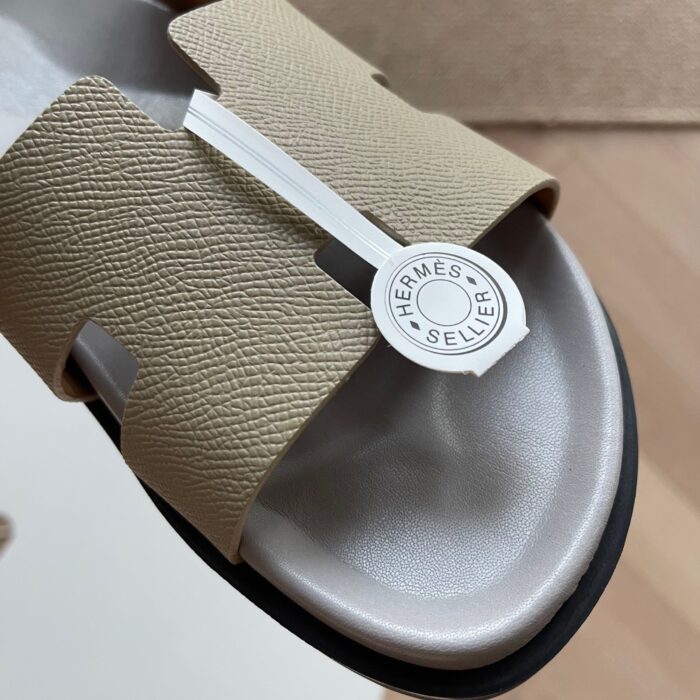 Sandalo Hermès minimalista con fibbia argento, design elegante e materiali di alta qualità.
