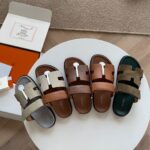 Sandali di lusso in tonalità earthy su tavolino moderno, stile elegante e comfort sofisticato.