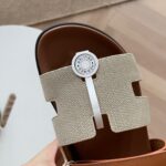 Sandalo elegante con fascia decorata a Herringbone e dettaglio a cerchio bianco.