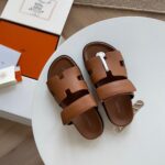 Sandali slip-on marroni di lusso con design moderno e dettagli eleganti, ideali per l’estate.