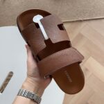 Sandalo in cuoio con dettaglio metallico argento, elegante e versatile per ogni occasione.