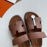 Sandali marroni moderni con fascia a lettere, ideali per moda e comfort estivi.