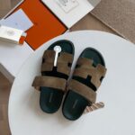 Sandali slider di lusso con design moderno in tissue verde oliva su tavolo bianco.