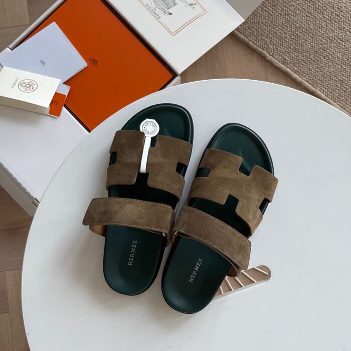 Sandali slider di lusso con design moderno in tissue verde oliva su tavolo bianco.