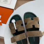 Sandali in suede con dettaglio circolare, su tavolo elegante, stile moderno e di lusso.