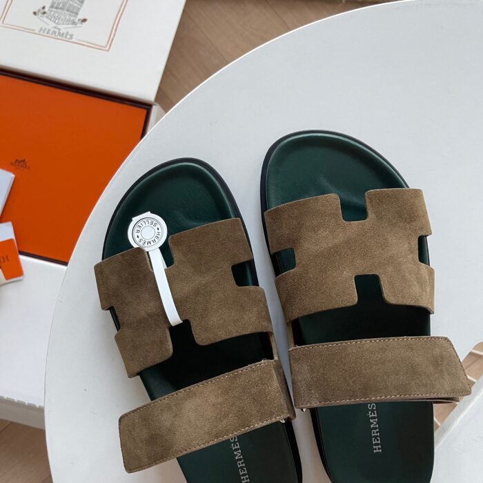 Sandali in suede con dettaglio circolare, su tavolo elegante, stile moderno e di lusso.
