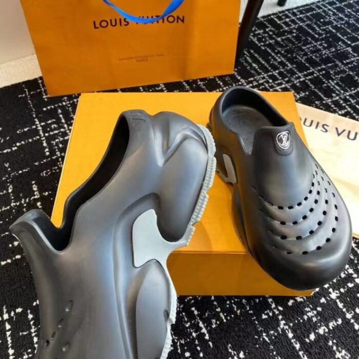 Scarpe Louis Vuitton in gomma nere su box arancione di lusso, stile moderno e pratico.