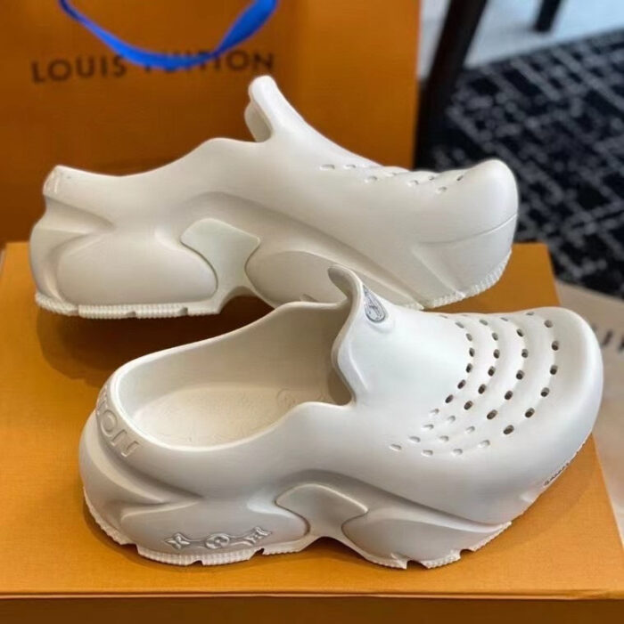 Ciabatte Louis Vuitton bianche su sfondo arancione, stile moderno e design luxuoso.