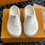 Scarpe moderne bianche con perforazioni su box arancione, stile minimalista e design elegante.