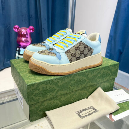 Sneakers Gucci con lacci gialli, dettagli luxury e design moderno su sfondo blu.