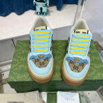 Sneakers di lusso con lacci gialli, dettagli monogramma e design raffinato in esposizione.
