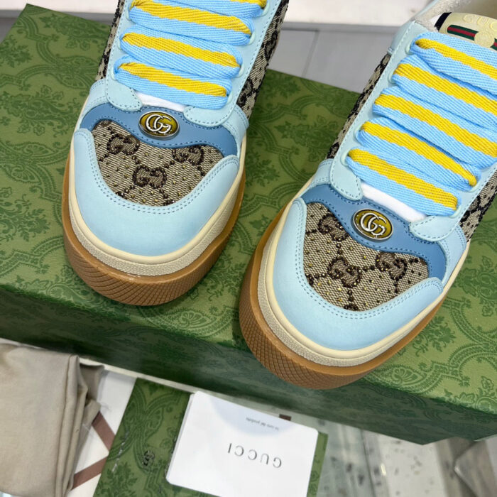 Sneakers Gucci blu e giallo con logo iconico e design elegante, perfette per uno stile di lusso.