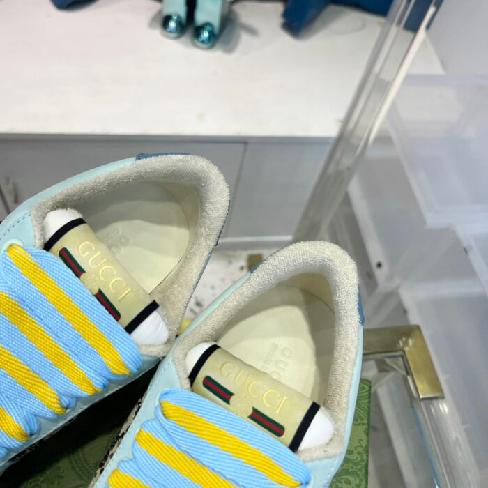Sneakers di lusso con dettagli colorati, logo elegante e design moderno in negozio raffinato.