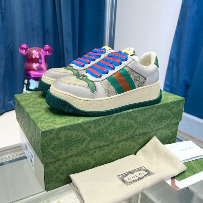 Sneaker di lusso colorate su scatola elegante con grande dettaglio e scultura rosa brillante sullo sfondo.
