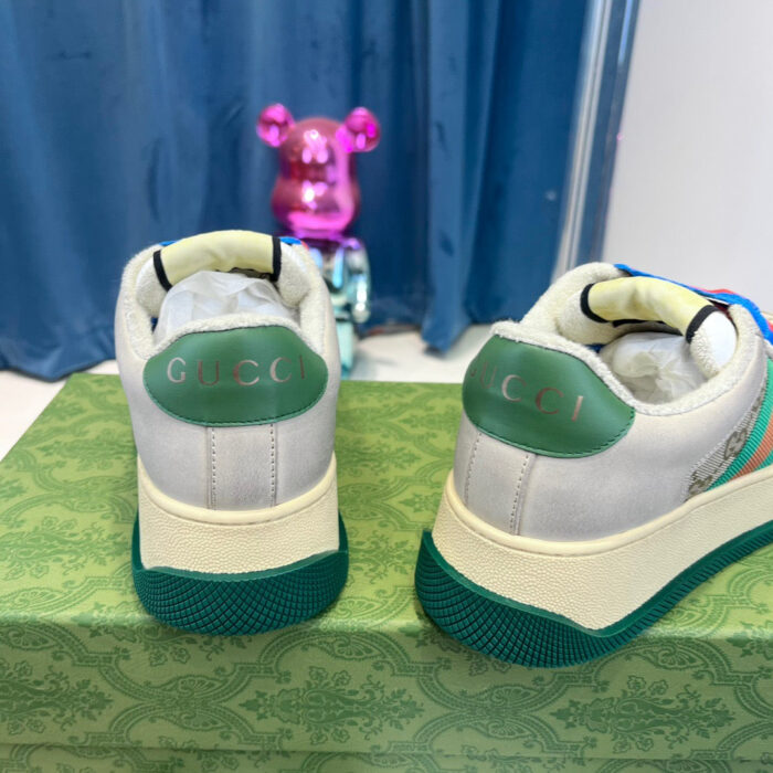 Sneakers Gucci sportive e lussuose con dettagli verdi e sfondo decorativo colorato.