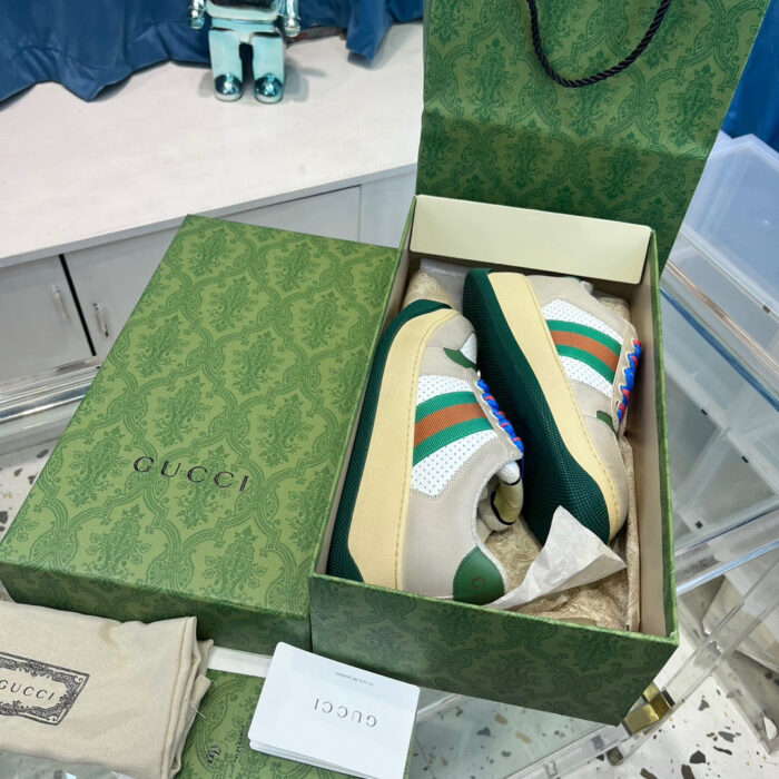 Scarpe Gucci in scatola di lusso con accessori, stile sofisticato e dettagli eleganti.