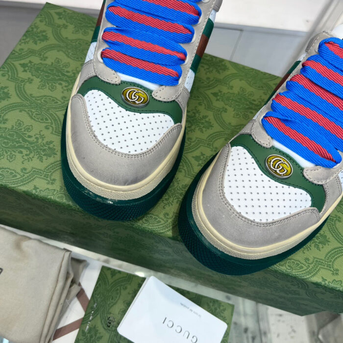 Sneakers di lusso con lacci blu, dettagli Gucci, materiali misti, stile sportivo elegante.