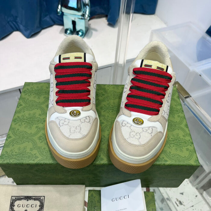 Sneakers Gucci con lacci rossi, dettagli gold e suola gommata in mostra.