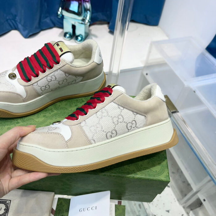 Sneaker Gucci beige con lacci rossi e suola platforme in gomma con trama esagonale.