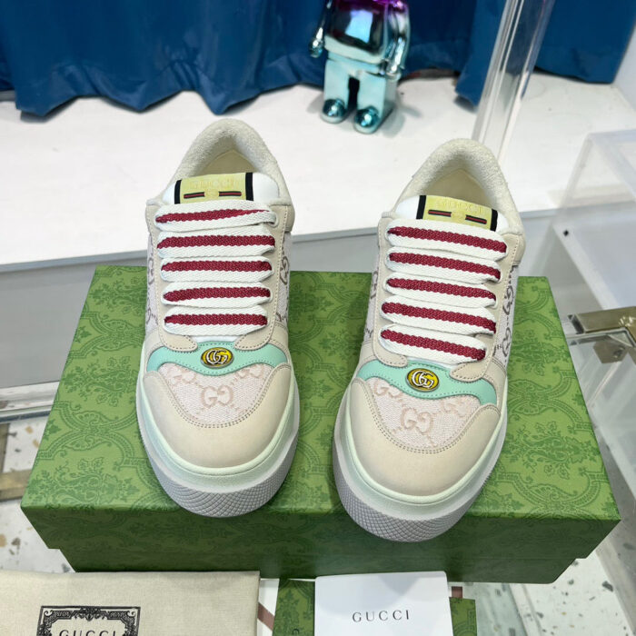 Sneakers di lusso con dettagli colorati, logo G e design elegante su sfondo blu.