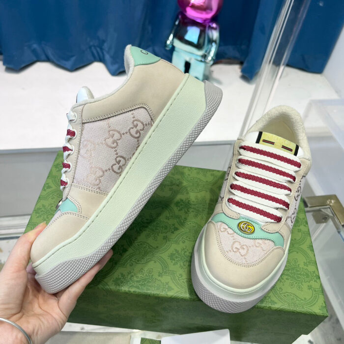 Sneakers di lusso Gucci con dettagli colorati, logo classico e design elegante su sfondo ricco.