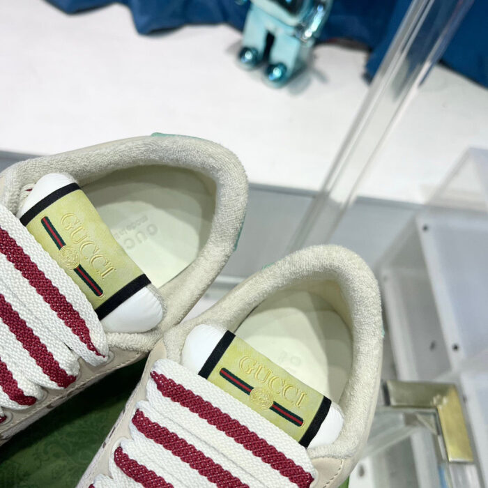 Sneakers trendy beige con strisce rosse e dettagli di alta qualità, ideali per stile e comfort.