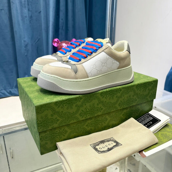 Sneakers Gucci beige con dettagli blu e elegante scatola verde, stile lusso e moda moderna.