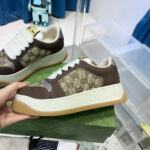 Sneaker in pelle con logo monogramma, suola spessa bianca e design moderno elegante.